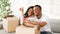 Happy black couple with house key and carton boxes looking at camera and smiling in their property, panorama