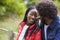 Happy black couple leaning on a fence in the countryside looking into each otherï¿½s eyes, close up