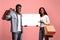 Happy black couple shopaholics holding empty board