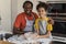 Happy Black Dad And Daughter Posing At Camera While Baking In Kitchen