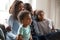 Happy black family with children sitting on couch watching tv