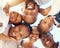 Happy black family in a huddle, face smile with mother, father, grandmother and their cute children from below. Group of