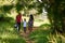 Happy Black Family Walking In City Park With Picnic Basket