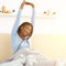 Happy Black Girl Waking Up Stretching Arms Sitting In Bedroom