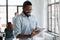 Happy Black male employee reading on digital device screen