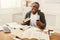 Happy black male student studying at table full of books