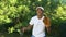 Happy black male teenager wearing white cap receiving and throwing baseball