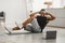 Happy Black Man Doing Elbow-To-Knee Abs Crunches At Laptop Indoor