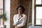 Happy Black millennial entrepreneur woman posing in contemporary loft space