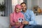 Happy Black Pregnant Muslim Couple With Baby Sonogram Picture Sitting On Couch