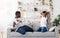 Happy Black Preteen Boy Enjoying Pillow Fight With His Dad At Home