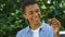 Happy black teenage boy showing auto keys to camera, getting driver license