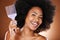 Happy black woman, hair care and comb in portrait with afro pick, beauty and self care by brown backdrop. African woman