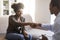 Happy black woman handshaking with man psychologist after therapy session