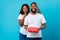 Happy black woman making romantic surprise for boyfriend giving box