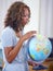 Happy black woman, teacher and earth globe for geography, history or planet in classroom or auditorium. African female