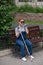 Happy blind pregnant woman sitting on bench and talking on smartphone.