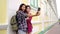 Happy blogger young female couple using smartphone for selfie.