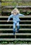 Happy blond child jumping wooden stairs