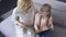 Happy blond granddaughter reading book with her caring grandmother, togetherness