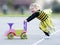 Happy blond little girl in bee costume pushing toy