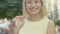 Happy blond mid-adult woman raising shopping bags on shoulder and turning to camera smiling. Portrait of charming