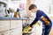 Happy blond school kid boy baking blueberry vanilla muffins in domestic kitchen, indoors. Funny lovely healthy child