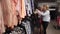 Happy blond women looking through clothes on rack