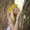 Happy blond young woman in park smiling, floral close up