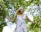 Happy blond young woman in park smiling, floral close up