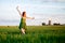 Happy blonde girl, dancing in a field full of yellow flowers. background of summertime and blue skies.