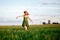 Happy blonde girl, dancing in a field full of yellow flowers. background of summertime and blue skies.