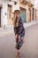 Happy blonde Mediterranean woman floral pattern dress posing