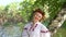 Happy blonde model posing in floral circlet near river