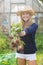 Happy blonde showing home grown vegetables