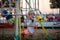 Happy blonde toddler child waving at the camera riding a carousel