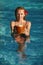 Happy blonde traveller chilling in pool with fresh coconut