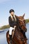 Happy blonde woman riding horse