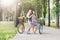 Happy boho chic girls ride together on bicycles in park