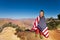 Happy boy bundled up in USA flag, Grand Canyon