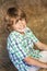 Happy Boy Child Sitting Smiling on Hay Bales