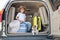 Happy boy in a cowboy hat and puppy jack russell terrier travel by car. A child and a funny little dog are sitting in