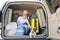 Happy boy in a cowboy hat and puppy jack russell terrier travel by car. A child and a funny little dog are sitting in