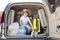 Happy boy in a cowboy hat and puppy jack russell terrier travel by car. A child and a funny little dog are sitting in