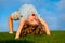 Happy boy doing a headstand on the grass in the summer sunshine. Funny happy little child standing on head upside down