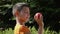 Happy boy is examining a delicious ripe apple outdoors