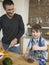 Happy Boy And Father Cooking Food Together In Kitchen