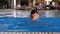Happy boy with flippers swims in a pool with blue water. Slow motion