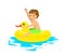 Happy boy floating on inflatable duck inner ring tube