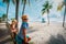 Happy boy and girl looking at tropical beach with palms